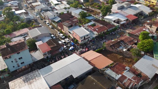 Aerial footage of a Semana Santa Easter procession in Concepci&oacute;n de Ataco, El Salvador. Colourful alfombras de aserr&iacute;n made from dyed sawdust and flowers create intricate street patterns.