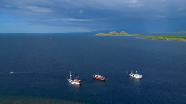 Traditional phinisi boats anchored komodo island. Smooth aerial view drone