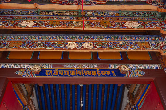 Ornate Tibetan temple entrance with painted beams and script in Gansu, China