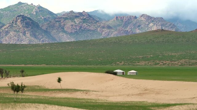 White ger tents on Gobi Desert sand dunes, Mongolia landscape, remote nomad camp. Traditional yurts rest beside windswept ridges, vast Asian wilderness, minimalist travel scene.
