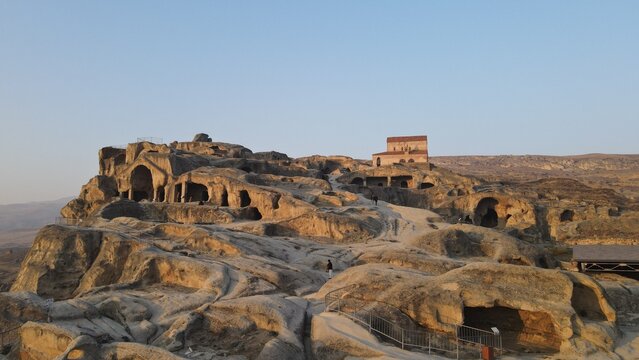 Ancient cave city Uplistsikhe with stone chambers and church at sunset in Georgia
