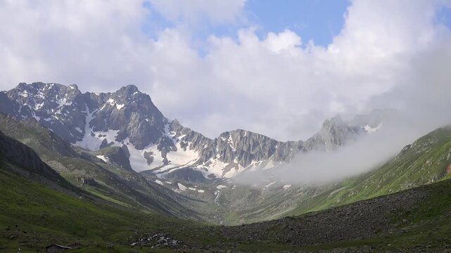 Timelapse fog and clouds swirl over snowy Kackar peaks in Turkey, Pontic range U valley. Fast motion mist drifts across glaciated summit ridges, Black Sea region highlands near Rize.