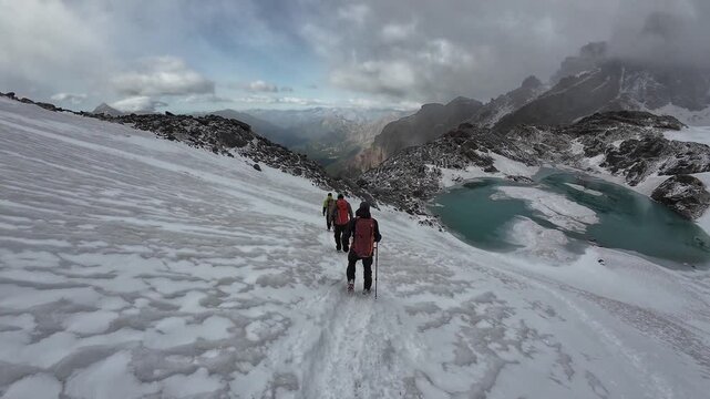 POV hiking on snow with other mountaineers and panorama view of Aosta Valley mountains in summer in Pennine Alps, Italy