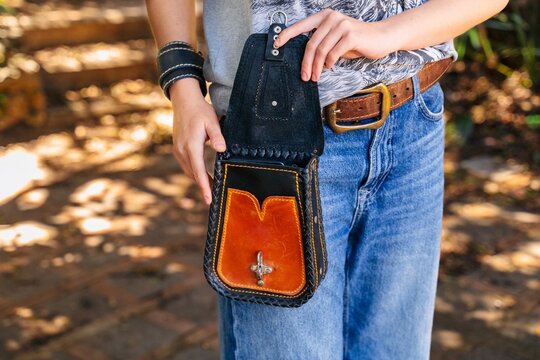 Open leather waist bag worn with denim outfit