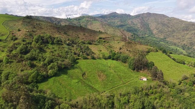 Aerial view of lush green mountains and pastures in Asturias, Spain