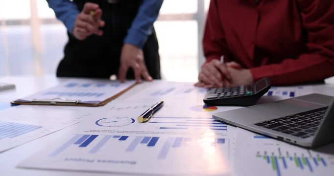 Group of confident business people point to graphs and charts to analyze market data, balance sheet, account, net profit to plan new sales strategies to increase production capacity.