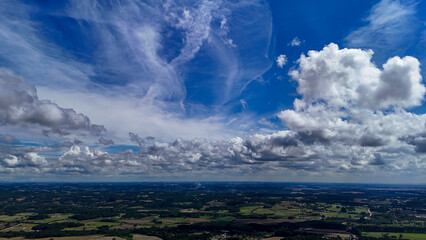 A wide-angle composition that highlights the contrast between a dynamic, cloud-laden sky and the vast, varied vegetation at its base. © Roberto