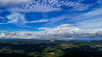 A wide-angle composition that highlights the contrast between a dynamic, cloud-laden sky and the vast, varied vegetation at its base. © Roberto