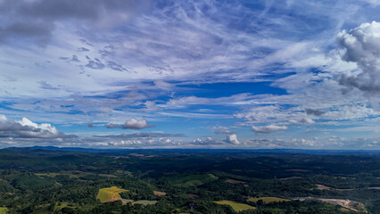 A wide-angle composition that highlights the contrast between a dynamic, cloud-laden sky and the vast, varied vegetation at its base. © Roberto