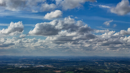 A wide-angle composition that highlights the contrast between a dynamic, cloud-laden sky and the vast, varied vegetation at its base. © Roberto