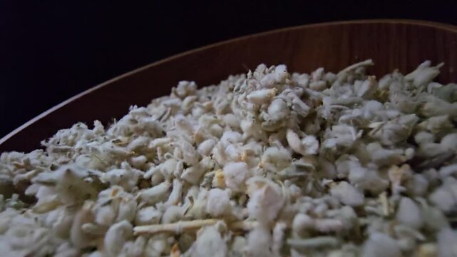 Macro shot of dried Teucrium polium (Felty Germander), a medicinal mountain herb from the Saudi desert used in folk medicine and blood sugar regulation, served in a wooden bowl.