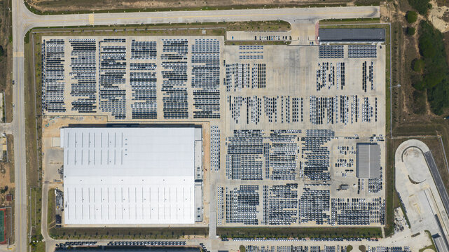 Aerial view of the BYD Thailand Rayong Office Building and a massive parking lot filled with thousands of new vehicles in Phananikhom, Rayong, Thailand.