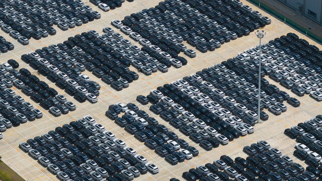 Aerial view of rows of new electric vehicles parked at the BYD Thailand Rayong Office Building under bright daylight in Phananikhom, Rayong, Thailand.