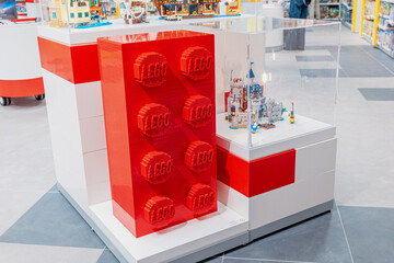 Naklejka premium 19 October 2025, Belgrade, Serbia: Red oversized LEGO brick and intricate castle model on display in a modern retail store, inviting play and creativity