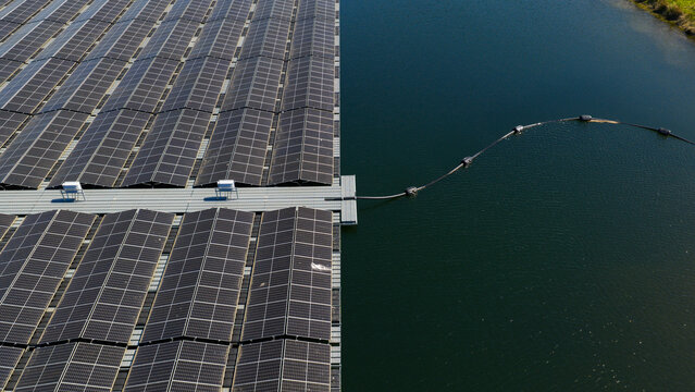 Aerial view of a large array of floating solar panels on a calm lake with a connecting cable and dark blue water Zwolle, Overijssel, Netherlands.