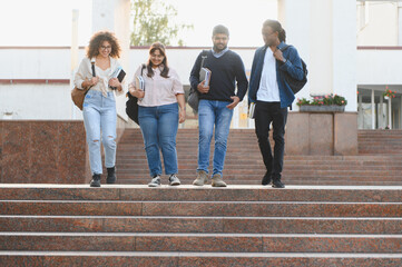 Obraz premium Diverse students walking downstairs on university campus