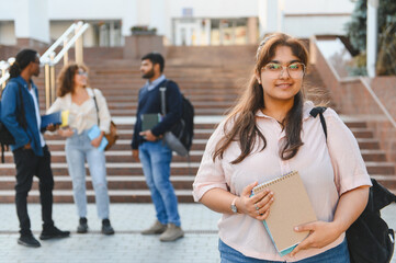 Young indian woman student standing on campus