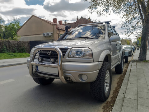 Polska, Ostrowiec Świętokrzyski, 23 kwietnia 2026, 12:31. Teren&oacute;wka Suzuki Grand Vitara w wiosenny dzień w mieście. Srebrny SUV (off roader) wyr&oacute;żnia się widocznym orurowaniem i relingiem dachowym.