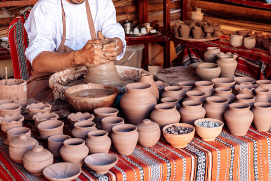 Clay pot emerging under skilled hands conveys artistic process centered on shaping, refinement and tactile interaction with medium
