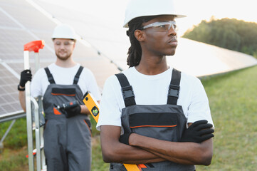 Fototapeta premium Diverse solar energy workers installing renewable power system