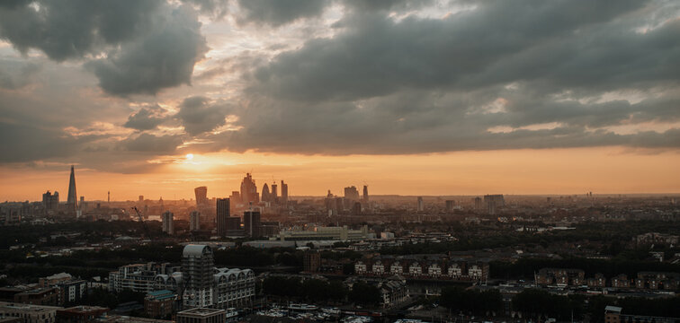 London skyline at sunset with dramatic clouds over city panorama.