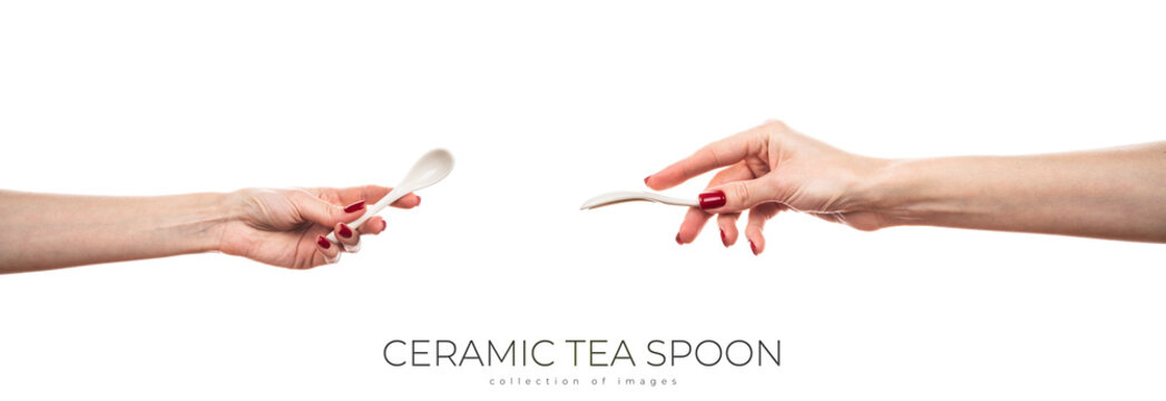 White ceramic tea spoon in female hand isolated on white background.