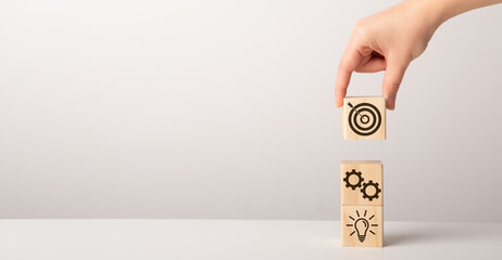 Goals Setting. Woman Hand Putting Wooden Blocks With Picture Of Target, Working Gearwheels And Lightbulb Over Gray Background. Goal Achievement Concept. Motivational Collage. Panorama, Copy Space © Prostock-studio