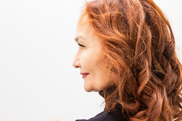 Profile portrait of successful 60 year old Asian woman with copper hair. Mature lady posing for headshot. Natural beauty, healthy skin and empowerment of aging, lifestyle concept. © Анастасия Бурлакова