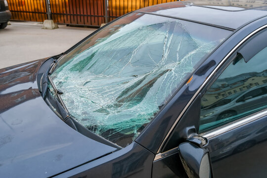 Damaged car windshield with severe cracks and shattered glass after collision broken front window auto damage concept