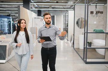 Salesman assisting female customer in showroom