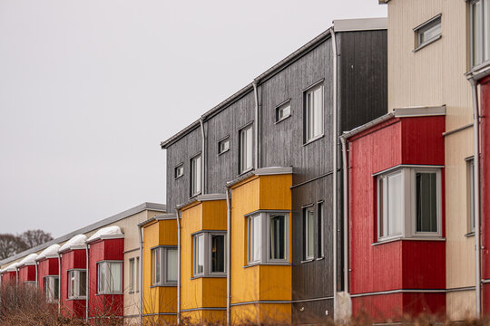 Colorful modern row houses with wooden facades in Scandinavian residential neighborhood.