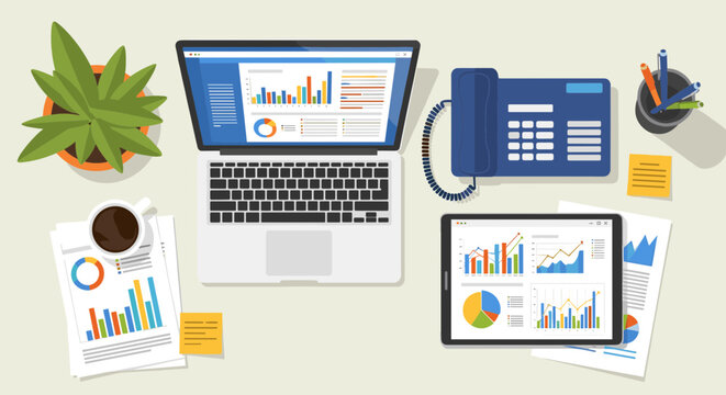 Business office desk with laptop and graphs on screen and paper