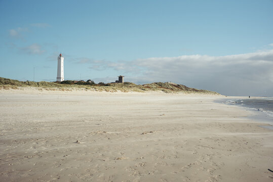 Endloser Sandstrand bei Bl&aring;vand mit blauem Himmel