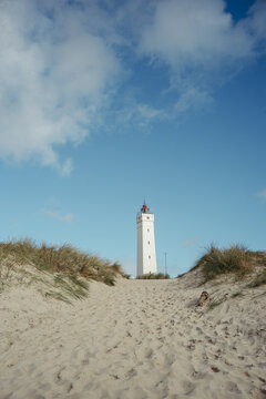 Strandpanorama mit Leuchtturm und blauem Himmel