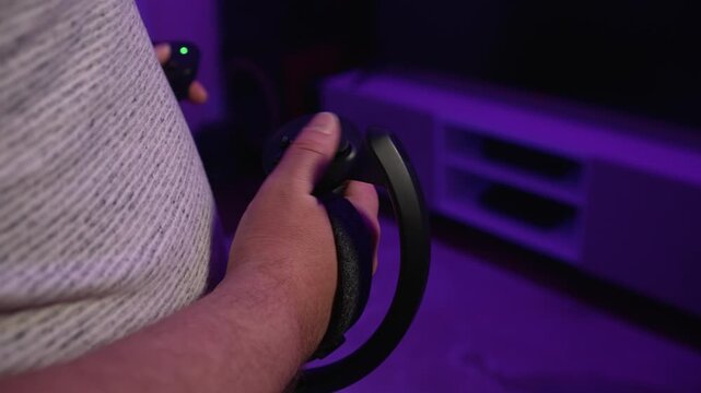 Close up of hand holding VR controller controlling virtual game demonstrating precise interaction with digital environment and control in gameplay under neon lighting