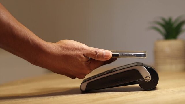 Customer using smartphone for contactless payment on a pos terminal. Convenient nfc technology for secure electronic financial transactions and cashless purchases at a store