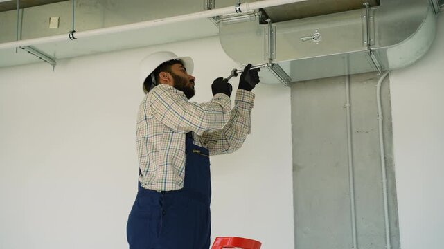 Hvac technician installing galvanized steel air duct