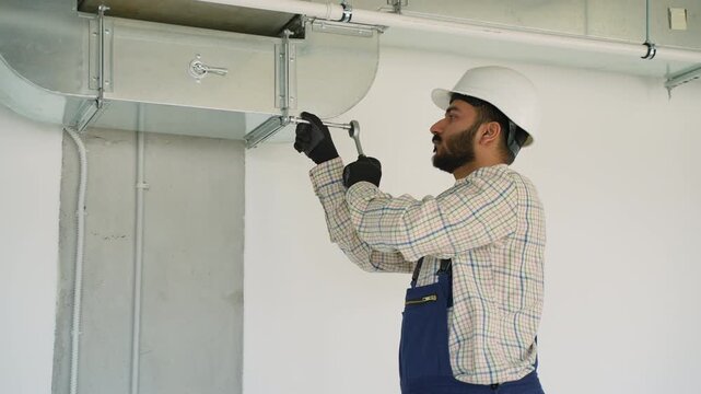 Ventilation system installer tightening ductwork bolt