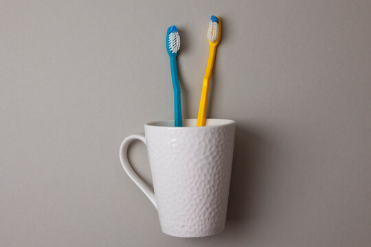 Minimalist Composition Featuring Toothbrushes And Toothpaste In Clean Studio Setting With Vibrant Colors
