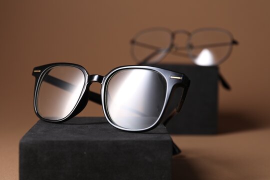 Stylish presentation of eyeglasses on brown background, closeup