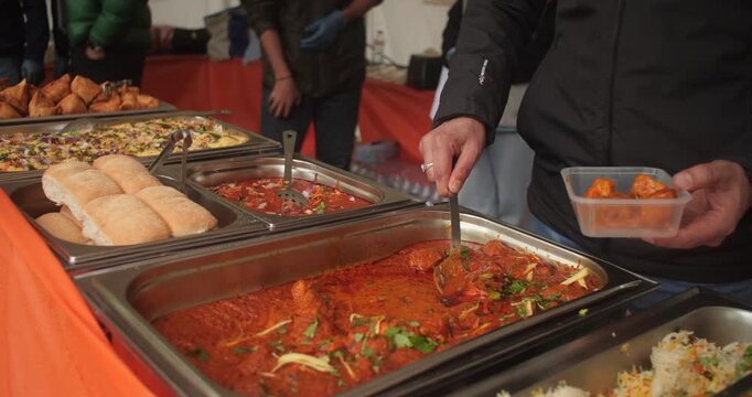 Indian street food chicken curry rice meal served from food truck into takeout container