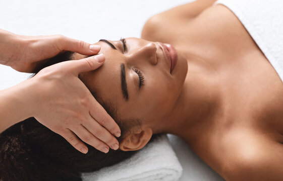 Closeup of african american woman having head massage at spa, view above