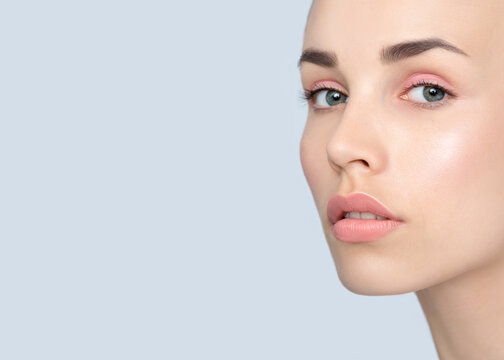 Beautiful young  women  face with clean perfect fresh skin. Portrait of beauty model with make-up, formed eyebrows  and long eyelashes.  Spa, skincare and wellness. Selective focus. Close-up