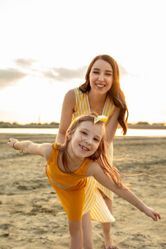 Mother and daughter walk outdoors. Woman and little girl have fun together on the river bank. Mom and her child. Family concept. Selective focus.