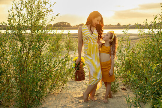 Mother and daughter walk outdoors. Woman and little girl spend time together on picnic. Mom and her child. Family concept. Selective focus.