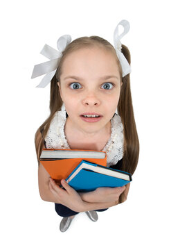 Happy cute child girl in school uniform holding books.