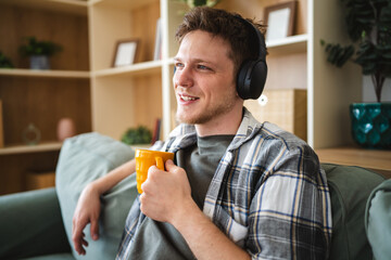 Young man relaxing at home enjoying music and coffee © Miljan Živković