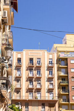 pastel colored traditional apartment building in Valencia spain with blue sky negative space