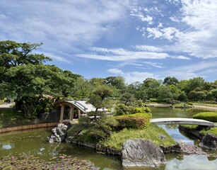 Fototapeta premium 池に浮かぶ中島と石組みのある日本庭園