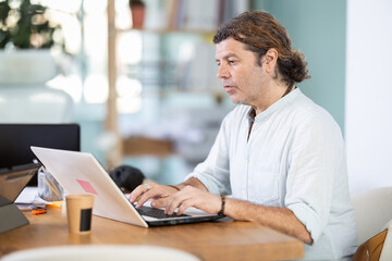 Obraz premium Working in modern office - businessman working on a laptop